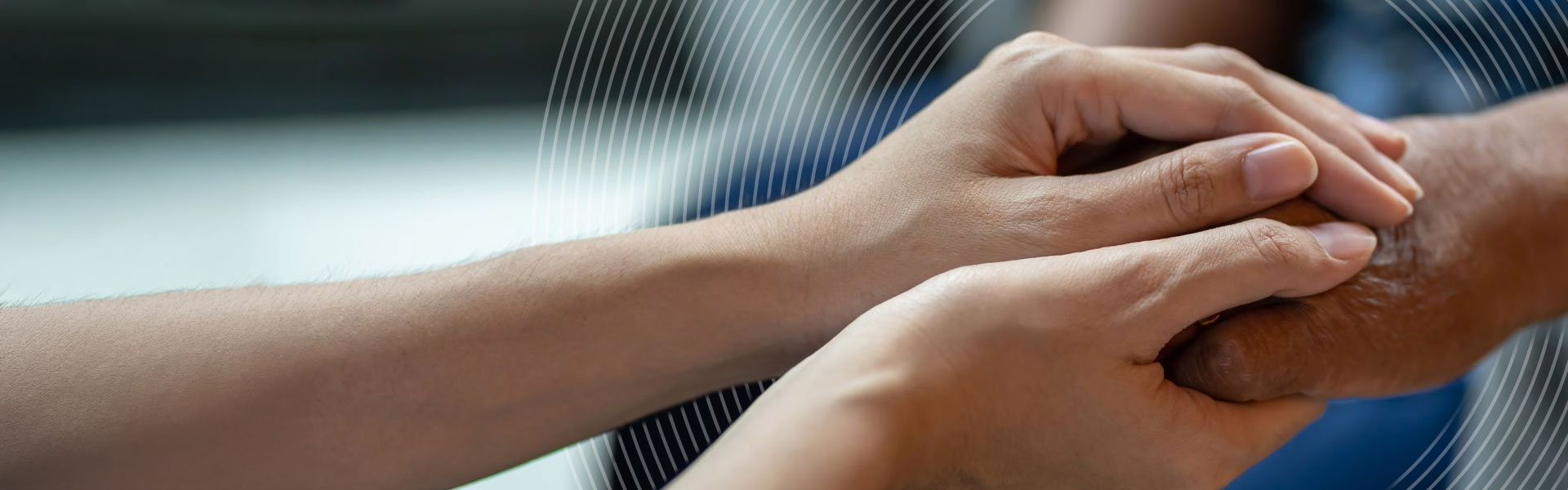 A close up image of a clinical nurse holding the hands of a patient.