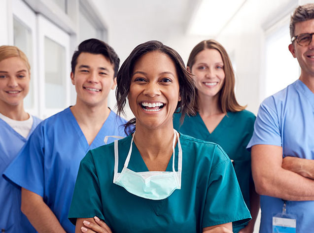 Multi-Cultural Medical Team Standing In Hospital Corridor