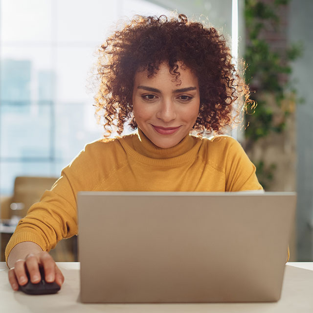 Young Stylish Female with Curly Hair Using Laptop Computer