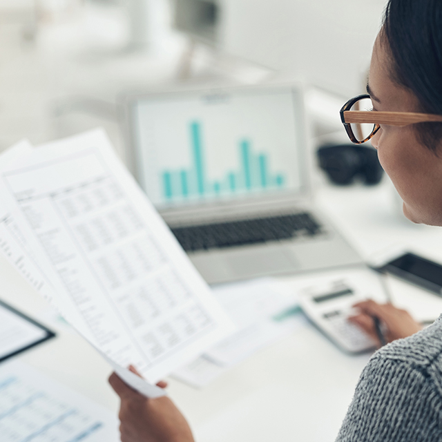 Busy with her tax return filing. Closeup shot of an unrecognisable businesswoman calculating finances in an office.