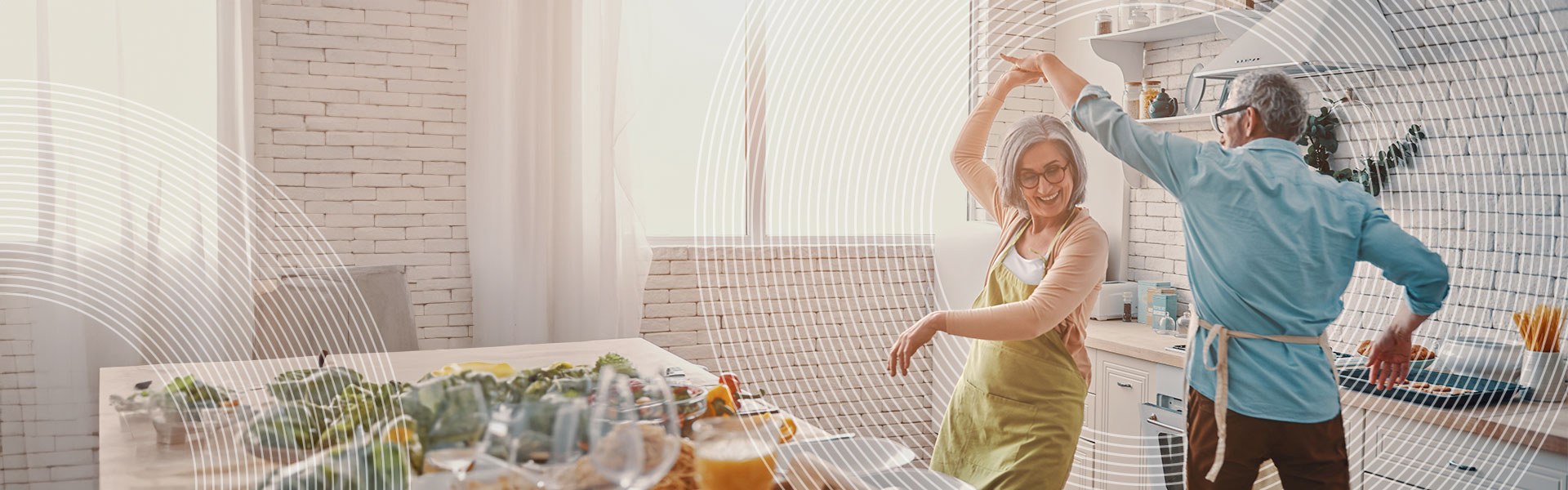 Pension Services banner - Beautiful playful senior couple in aprons dancing and smiling while preparing healthy dinner at home