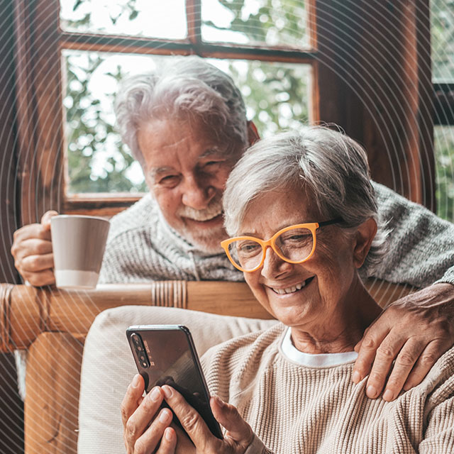 NHS Pension Services by NHS SBS. An older couple drinking tea checking looking at a mobile phone