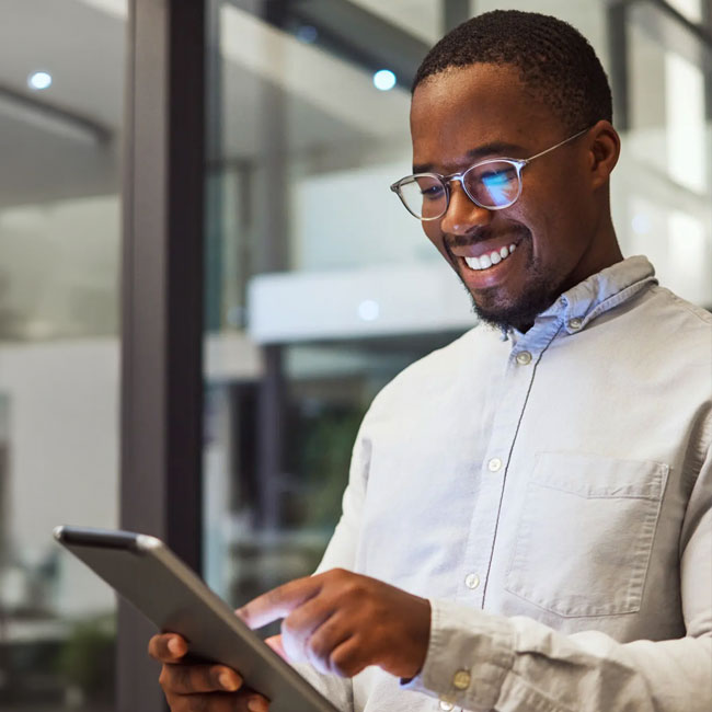 a man holding a computer laptop smiling at the results it shows